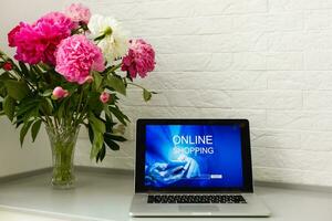 woman holding laptop for online shopping photo