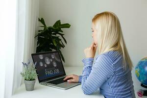 Unemployed bored young woman searching online for job photo