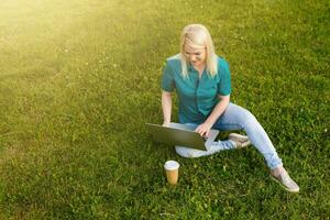 mujer buscando trabajo con un ordenador portátil en un urbano parque en verano foto