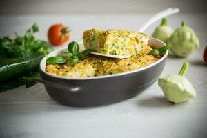 vegetable casserole of patissons, zucchini, carrots in a ceramic form . photo