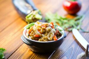 berenjena frito salteado con otro vegetales en un plato foto