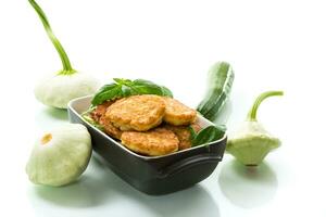 fried vegetable pancakes from squash and zucchini with herbs photo