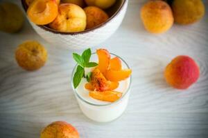 Healthy breakfast of homemade yogurt in a glass with fresh apricots photo