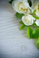 beautiful white summer roses, on a wooden table photo