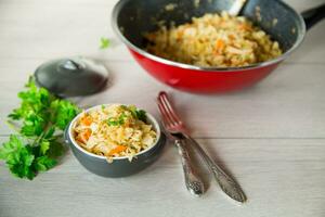 Braised cabbage with carrots, onions and herbs in a ceramic bowl photo