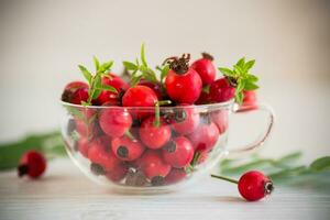 ripe red rose hips on a wooden table photo