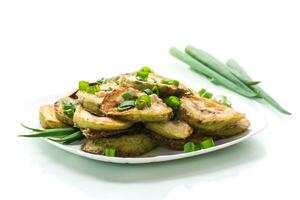 fried zucchini in circles with fresh herbs in a plate isolated on white photo