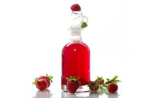 sweet cooked strawberry syrup in a glass decanter photo
