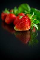 Ripe juicy red strawberry on black background photo