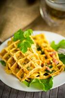 Egg omelet stuffed with greens and sausage fried in the form of waffles photo