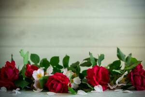 background of many red roses on a light wooden photo