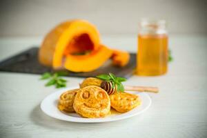 sweet lush pumpkin pancakes with honey in a plate photo