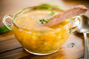 cooked pea soup with ribs smoked in a plate photo