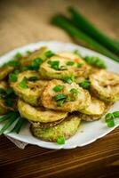 fried zucchini in circles with fresh herbs in a plate photo