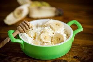 homemade cottage cheese in a bowl with bananas and honey photo