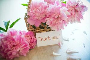 several branches of blooming pink peonies on a wooden table photo