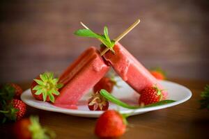 homemade strawberry ice cream on a stick made from fresh strawberries in a plate photo