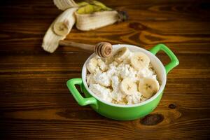 homemade cottage cheese in a bowl with bananas and honey photo