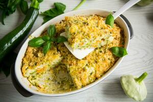 vegetable casserole of patissons, zucchini, carrots in a ceramic form . photo