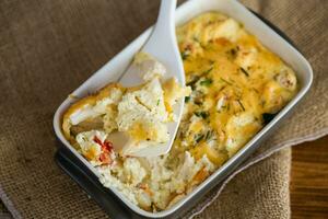 baked cauliflower with chicken fillet and vegetables topped with cheese photo