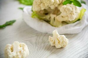 inflorescences of small cauliflower on a light wooden table photo