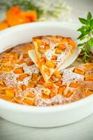 sweet pumpkin pie with pumpkin slices in a ceramic mold photo