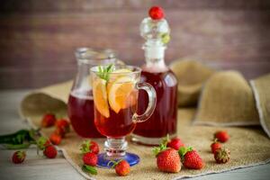 refreshing cool strawberry lemonade with lemon, ice and mint in a glass photo