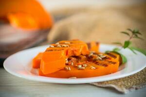 sweet baked grilled pumpkin with seeds in a plate photo