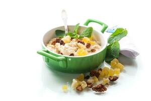 cooked boiled sweet oatmeal with nuts and candied fruits in a bowl photo