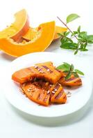 sweet baked grilled pumpkin with seeds in a plate photo