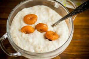 cooked boiled sweet oatmeal with dried apricots in a bowl photo