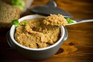 homemade meat pate in a ceramic bowl on a wooden table photo