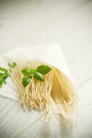 homemade thin dried egg noodles in paper bag with basil photo