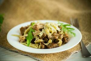 Homemade boiled noodles with meat and eggplant in a plate photo