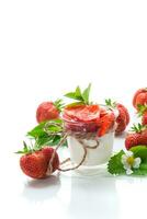 sweet homemade yogurt with strawberry jam and fresh strawberries in a glass cup photo