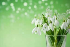 AI generated a bouquet of snowdrops in a transparent tequila glass. splashes of water on petals. first spring flowers. forest. hello spring. women's day concept. green blur background. generative ai. photo