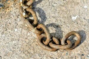 a rusty chain is shown on a concrete surface photo