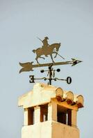 a weather vane on top of a brick building photo