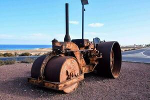 an old rusted tractor sitting on the side of the road photo