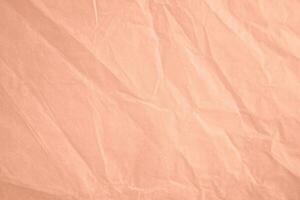 wrinkled paper texture in peach color of the year 2024 photo