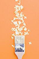 white hydrangea flowers and paint brush on a Peach Fuzz background with copy space. photo