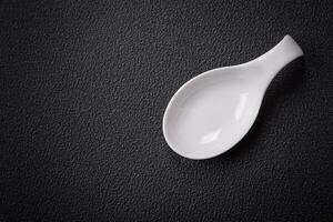 Beautiful empty white ceramic gravy boat on a textured concrete background photo