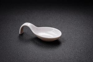 Beautiful empty white ceramic gravy boat on a textured concrete background photo