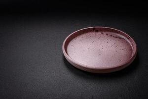 Bumpy empty ceramic plate on a textured concrete background photo