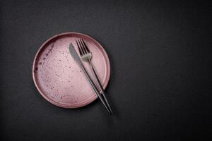 Bumpy empty ceramic plate on a textured concrete background photo