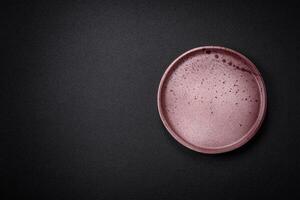 Bumpy empty ceramic plate on a textured concrete background photo