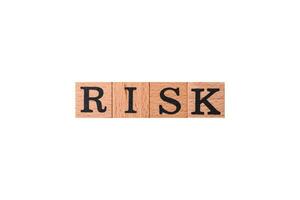 The inscription risk with wooden cubes on a dark concrete background photo