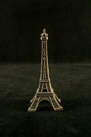 a small brass eiffel tower on a black background photo