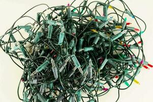 a pile of christmas lights on a white surface photo