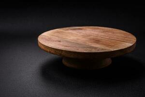 Beautiful round wooden cake stand on a textured concrete background photo